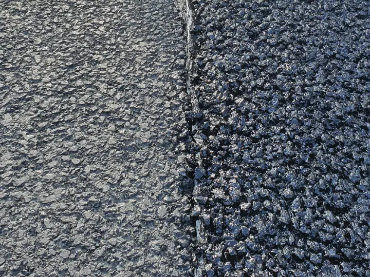 The edge of the new layer and its connection to the adjacent pavement.